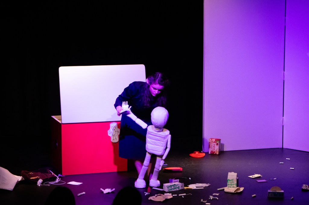 Maxi the menstrual puppet waves hello to the audience. Amy Atkins is puppeteering.