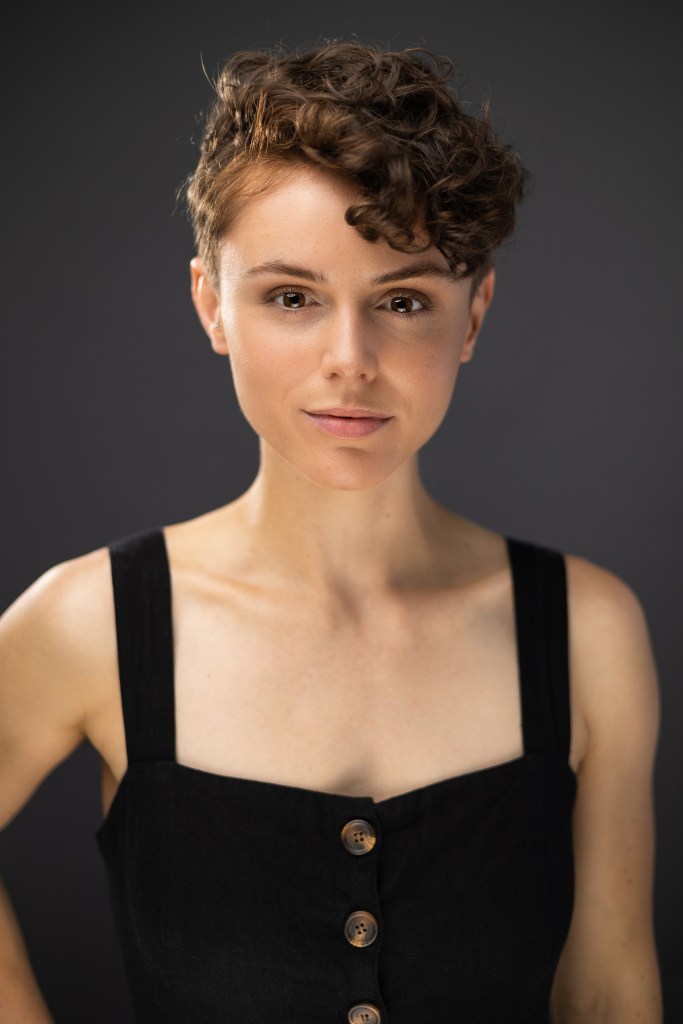 Amy smiling, lips together, into the camera.